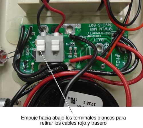 empuje hacia abajo los terminales blancos para quitar los cables rojo y negro de la electrónica del carrete de alimentación de solinst.