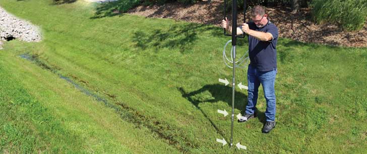 field technician installing solinst 615ml multilevel drive point piezometer with 3 discrete monitoring ports