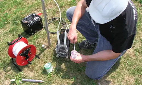 solinst peristaltic pump being used to take a groundwater sample from a drive point piezometer